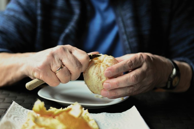 older adult peeling orange