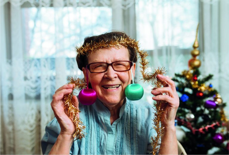 Senior with Christmas tree in background