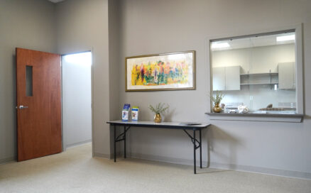 office waiting area with table and painting on the wall