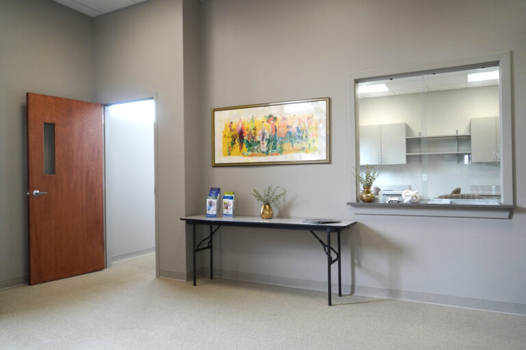 office waiting area with table and painting on the wall