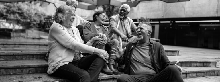 group of seniors laughing while sitting on steps